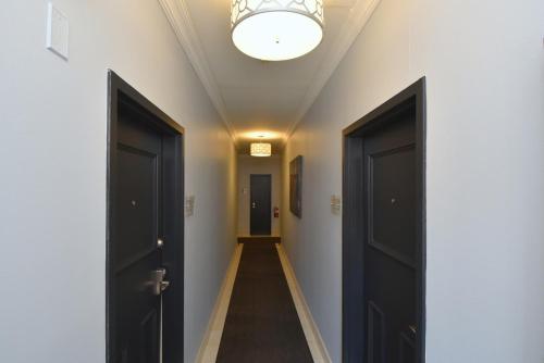 a hallway with two black doors and a hallway with at The SoMa Furnished Residences in Hamilton