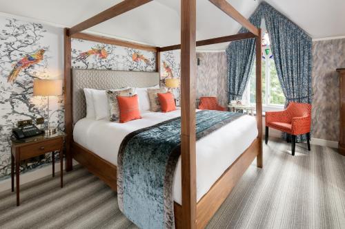 a bedroom with a canopy bed with orange pillows at Cedar Manor in Windermere