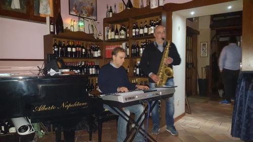 a man playing a keyboard and a man playing a saxophone at Locanda della Bottega in Fisciano