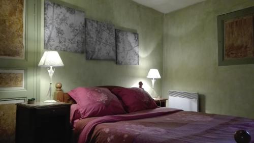 - une chambre avec un lit doté d'un couvre-lit violet et de 2 lampes dans l'établissement Gite de charme au coeur de la Bourgogne, à Santigny