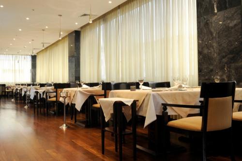 a dining room with tables and chairs with white table cloth at Radisson Blu Hotel Lisbon in Lisbon