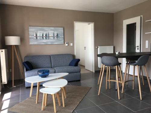 a living room with a couch and a table and chairs at Residence Belle Epoque in Wimereux