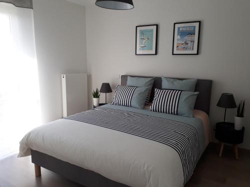 ein Schlafzimmer mit einem großen Bett mit zwei Kissen in der Unterkunft Residence Belle Epoque in Wimereux