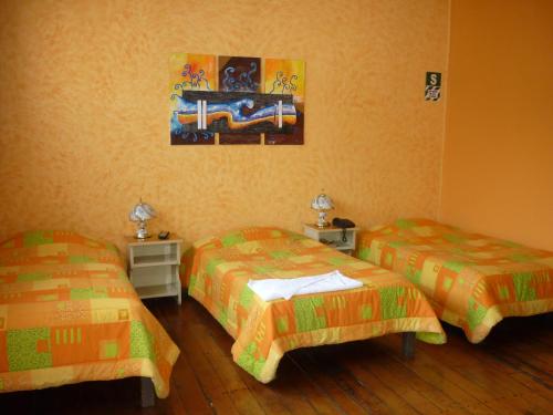 a room with two beds and a painting on the wall at Hostal Los Balcones de Moral y Santa Catalina in Arequipa
