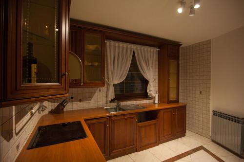 a kitchen with wooden cabinets and a sink and a window at Villa Royale Krk in Krk