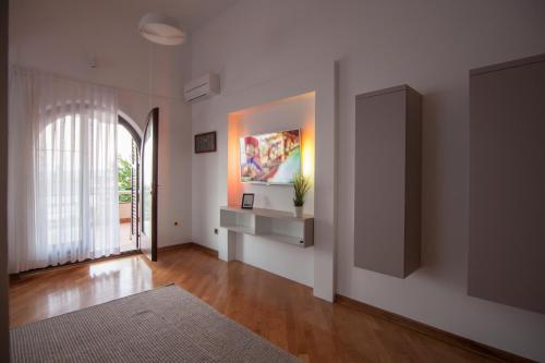 a living room with white walls and a large window at Villa Royale Krk in Krk