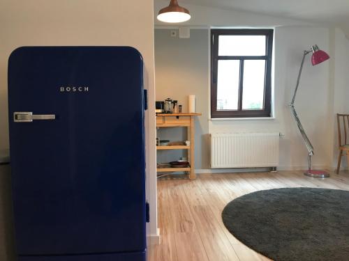 a blue refrigerator in a room with a desk at Hinterhaus Apartments in Leipzig