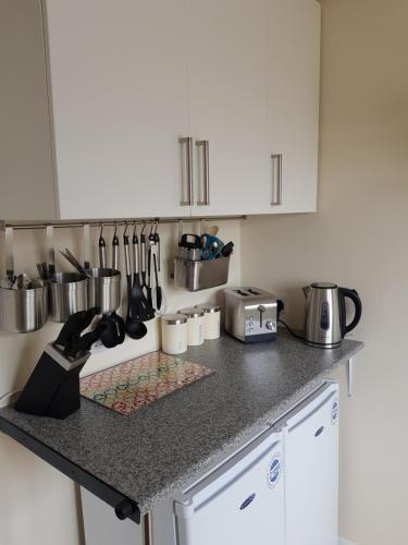 a kitchen with white cabinets and a counter with utensils at Braganza House in Portsmouth