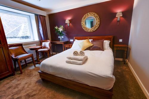 1 dormitorio con 1 cama con toallas en Friars Wynd Hotel, en Stirling