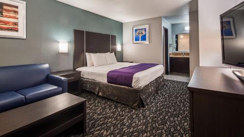 Piccola camera d'albergo con letto e divano di Best Western Desert Villa Inn a Barstow