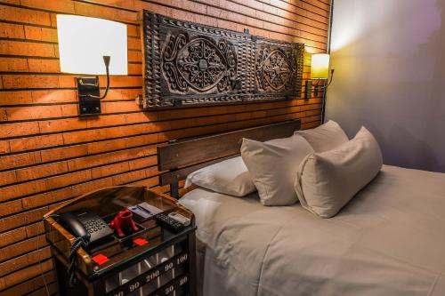 a bedroom with a bed with a wooden wall at Alfonsina Hotel Boutique in Santa Cruz de la Sierra