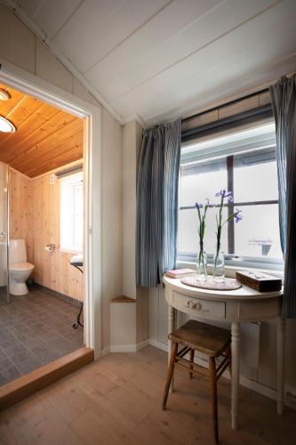 a bathroom with a table with a vase of flowers on it at Lifjellstua in Lifjell
