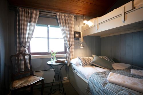 a bedroom with two beds and a chair and a window at Lifjellstua in Lifjell