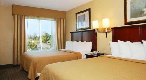 a hotel room with two beds and a window at Quality Inn & Suites Bensalem in Bensalem
