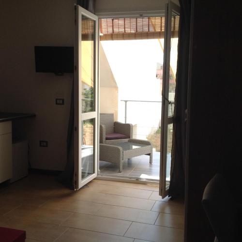 an open door to a patio with a chair outside at Vianova Affittacamere in Giurdignano
