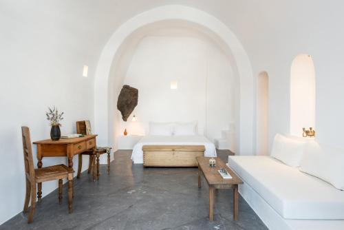 a living room with a bed and a couch at Chelidonia Luxury Suites in Oia