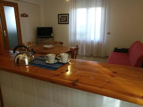 um balcão de cozinha com uma chaleira e chávenas de chá em Confetti di Mandorla beach house em Avola