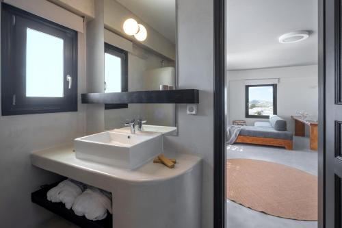 a bathroom with a sink and a living room at IfestAu.4 Suites in Fira