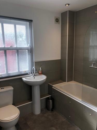 a bathroom with a sink and a toilet and a tub at 1 Laurel Court in Ulverston