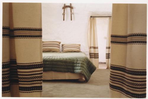 a bedroom with a bed in a room with a window at Cuevas Alcobas in Baza