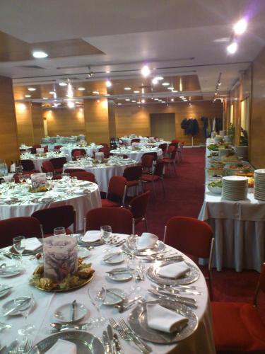 a room filled with tables and chairs with white tablecloths at Radisson Blu Hotel Lisbon in Lisbon