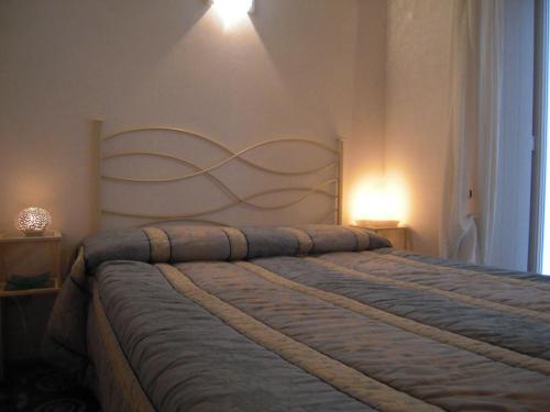 a bed in a bedroom with two lights on the wall at B&B Casa Dorsi in Polignano a Mare