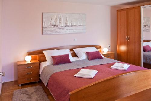 a bedroom with a large bed with two towels on it at Apartment Noel in Kaštela