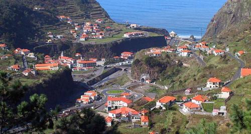 a small town on a hill with the ocean at Pereira Place in São Vicente