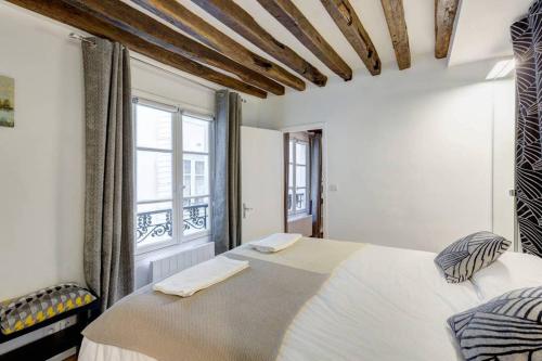 パリにあるQuiet, Cozy, Design Apartment in Parisのベッドルーム(大型ベッド1台、窓付)