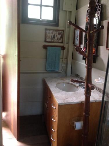 a bathroom with a sink and a mirror at Chales Bamboo Jungle in Petrópolis