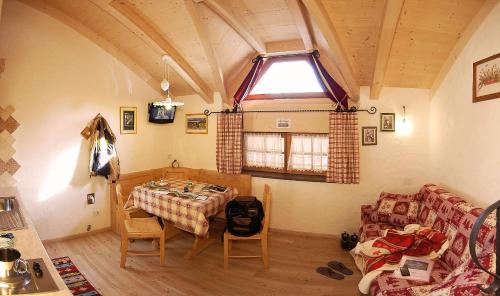 a room with a table and a couch and a window at Camping Catinaccio Rosengarten in Pozza di Fassa