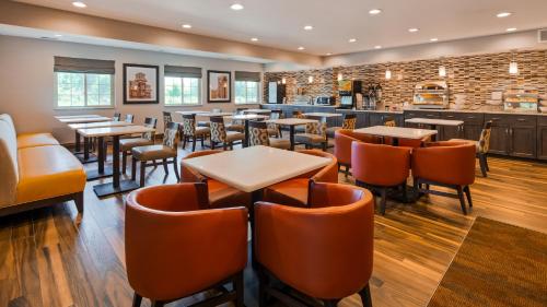 a restaurant with tables and chairs and a bar at Best Western Plus North Joliet in Joliet