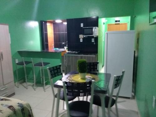 cocina con mesa, sillas y nevera en Apartamento Edificio Ajuricaba, en Manaus
