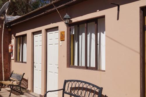 a couple of benches sitting outside of a building at Hostal Intipara in San Pedro de Atacama