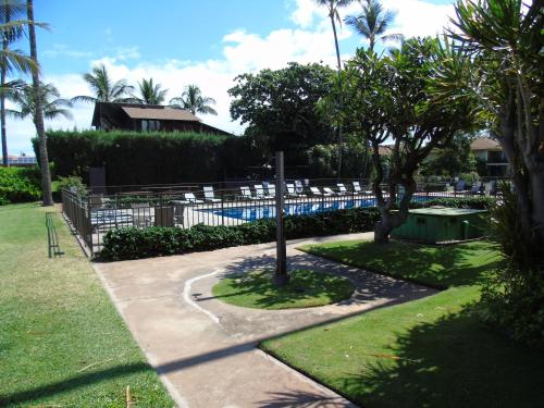 a pool with chairs and a pole in a yard at Aloha WAI in Kihei