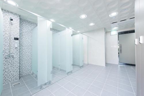 a bathroom with a row of stalls in a room at Fortuna Hotel in Tongyeong