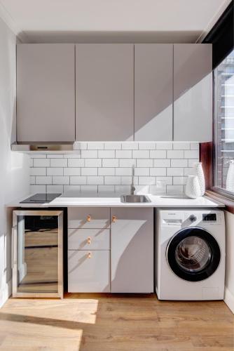 a kitchen with a washing machine and a sink at Regents Court Sydney in Sydney