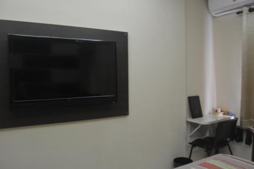 a flat screen tv hanging on a wall at Hotel Calstar in Sao Paulo