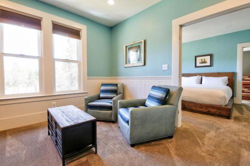 a hotel room with a bed and two chairs at The Groveland Hotel in Groveland