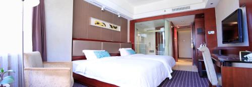 a bedroom with a bed and a desk and a television at Kunming Haitian Hotel in Kunming