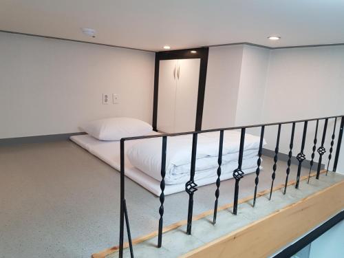 a small bedroom with a bed and a balcony at Maison de Geoje in Geoje 