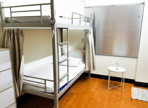a bedroom with two bunk beds and a table at Gather in Tainan