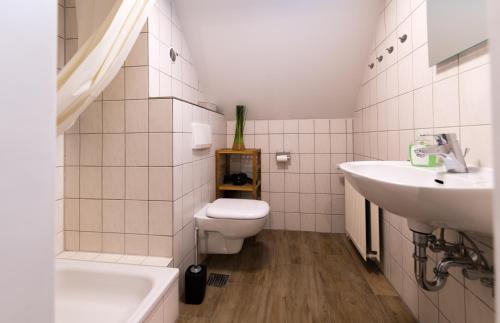 La salle de bains blanche est pourvue de toilettes et d'un lavabo. dans l'établissement Schloß Auerbach Kleine Ferienwohnung, à Bensheim