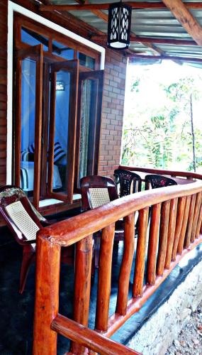 a porch with chairs and windows on a house at Cozy Homestay Waterfall Road Ella in Ella