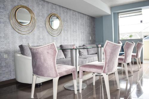 a dining room with a table and chairs and mirrors at Principal New Leisure Hotel in Paralia Katerinis