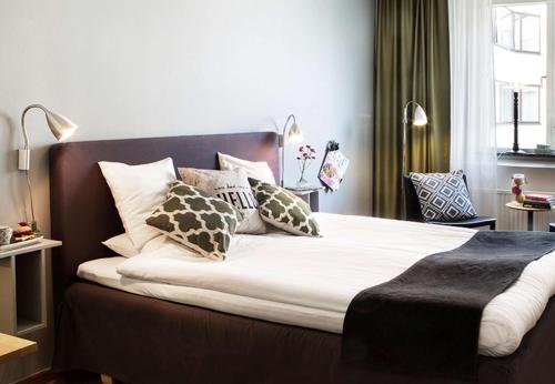 a bedroom with a large bed with pillows at City Central Hotel Örebro by First Hotels in Örebro