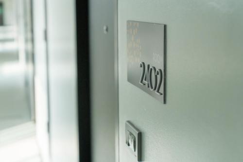 a door with a sign on the side of it at Phavina Grand Boutique in Rayong
