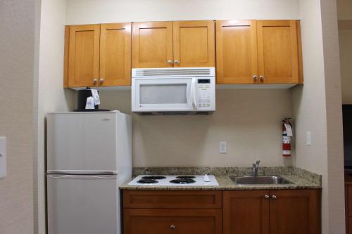 a kitchen with a white refrigerator and a microwave at Best Western King George Inn & Suites in Surrey