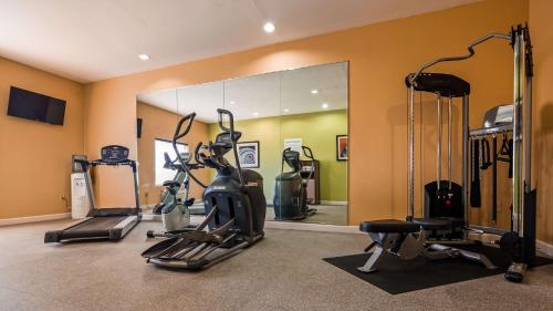 a gym with tread machines and a mirror at Best Western Troy Hotel in Troy