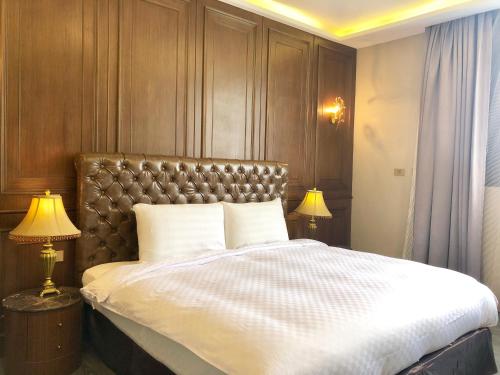 a bedroom with a large bed and two lamps at Puli Story House in Puli